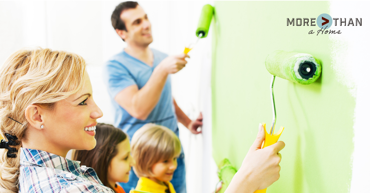 Family painting their new home at Brunswick Crossing with a bright green summer paint color—highlighting fresh, seasonal design inspiration for homeowners.